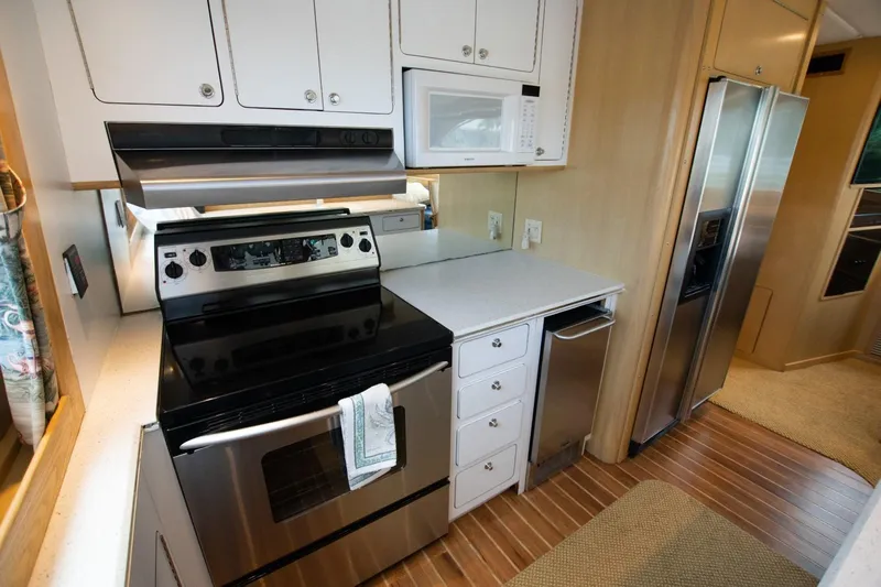 Andiamo Yacht Photos Pics Kitchen area of 1991 Donzi 65 Sportfisher yacht with modern appliances.