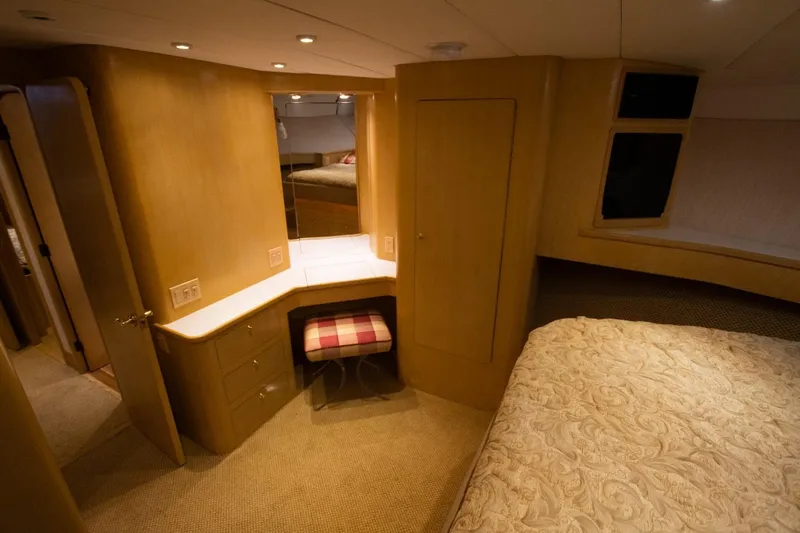 Andiamo Yacht Photos Pics Luxurious interior of 1991 Donzi 65 Sportfisher yacht with elegant wood finish and cozy bedding.