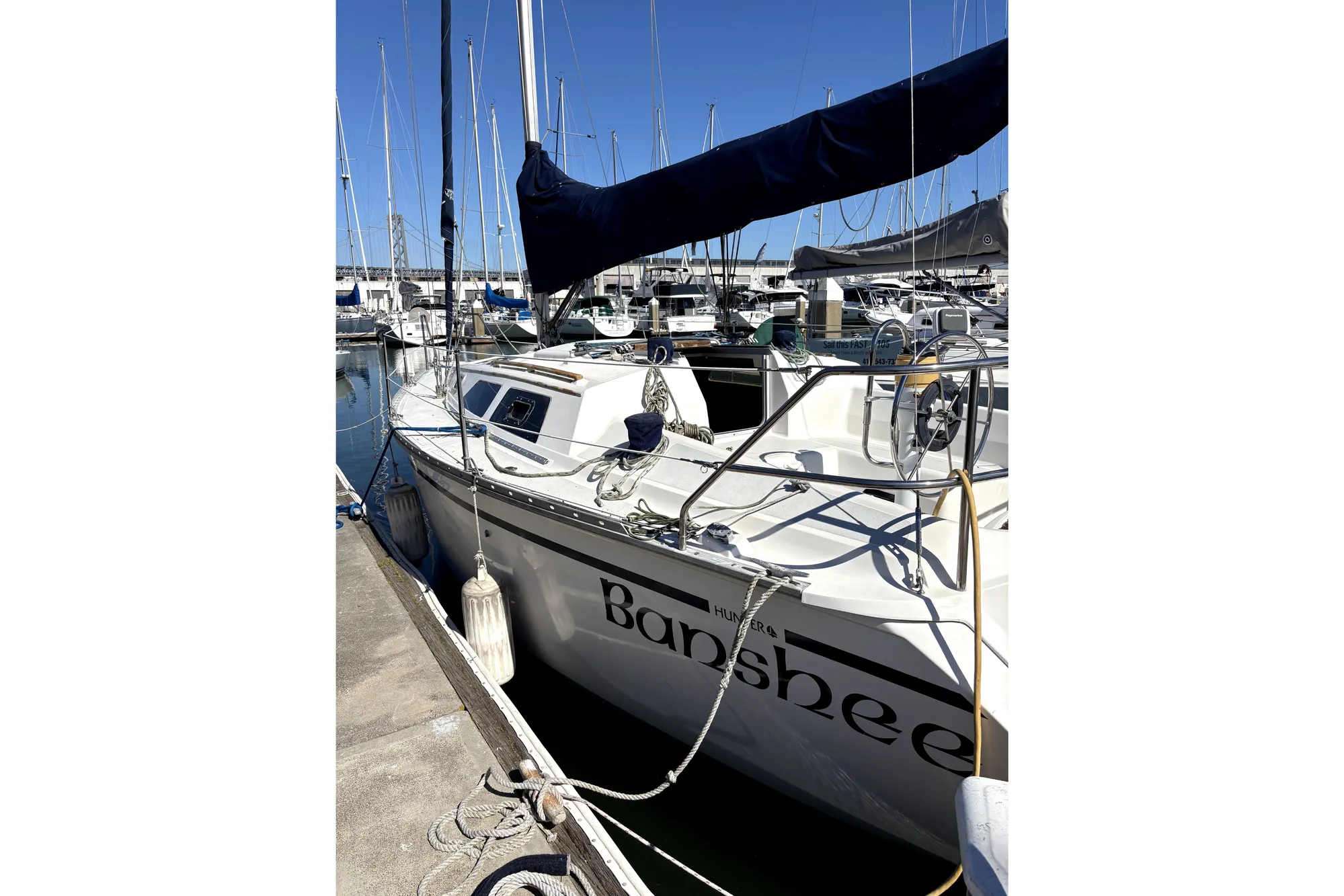 1989 Hunter 30 sailboat named "Banshee" docked at a marina.