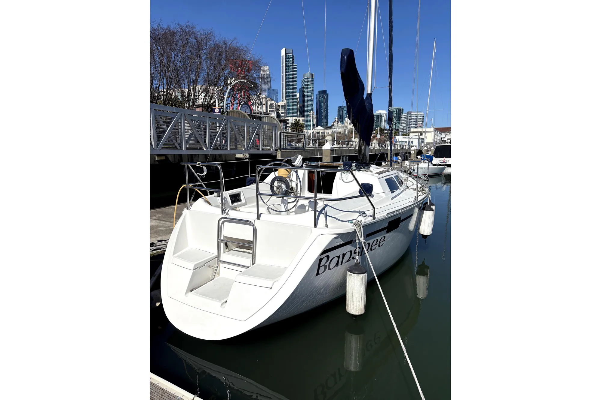 1989 Hunter 30 sailboat docked in marina with city skyline background.
