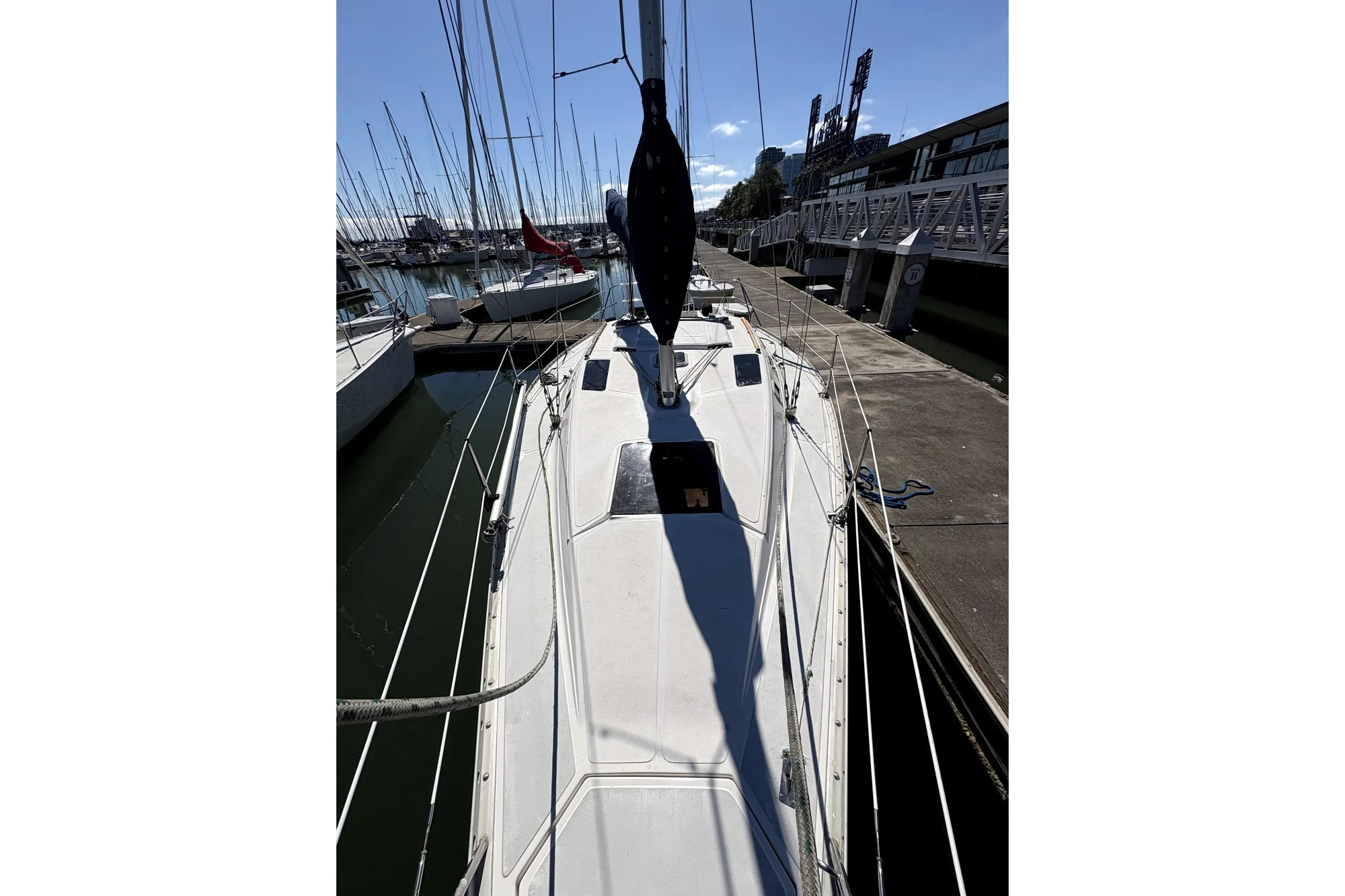 1989 Hunter 30 sailboat docked at marina, sunny day, clear sky.