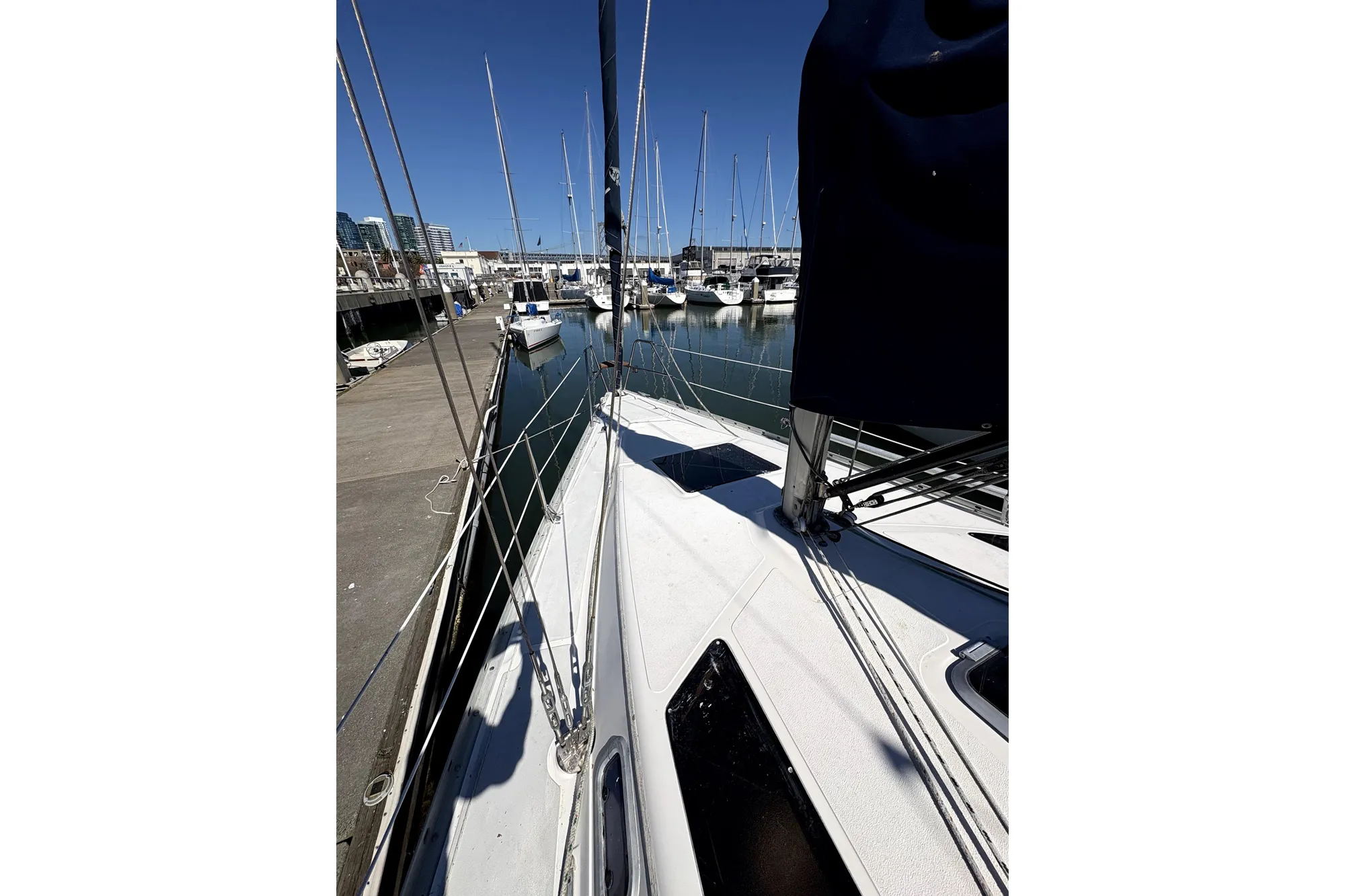 1989 Hunter 30 sailboat docked at marina under clear blue sky.