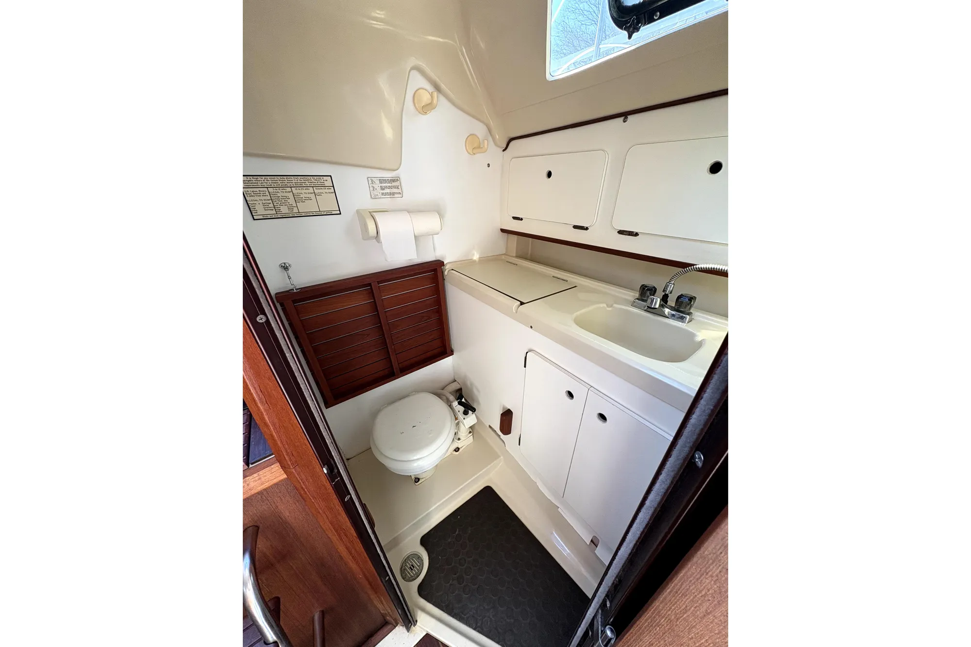 1989 Hunter 30 sailboat bathroom with sink, toilet, and storage cabinets.