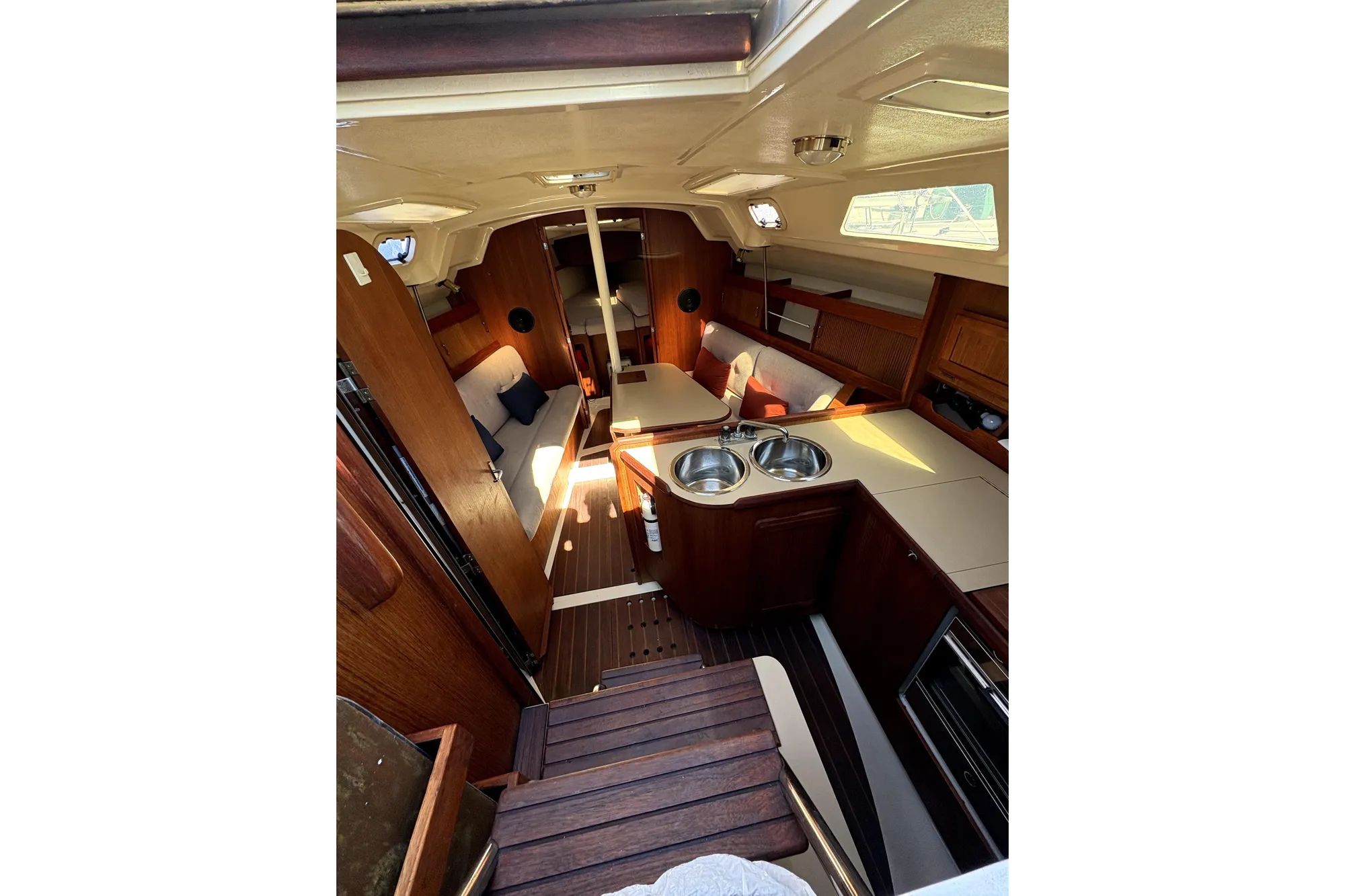 Interior of 1989 Hunter 30 sailboat with wood finish and compact kitchen.