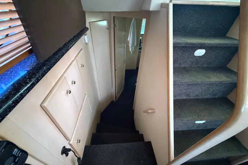 Il Danza Yacht Photos Pics Interior stairs of 1999 Carver 406 Aft Cabin Motor Yacht, featuring carpeted steps and storage cabinets.