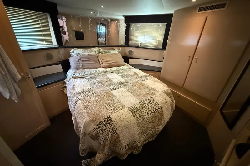 Il Danza Yacht Photos Pics Cozy bedroom in 1999 Carver 406 Aft Cabin Motor Yacht with patterned bedding and ambient lighting.