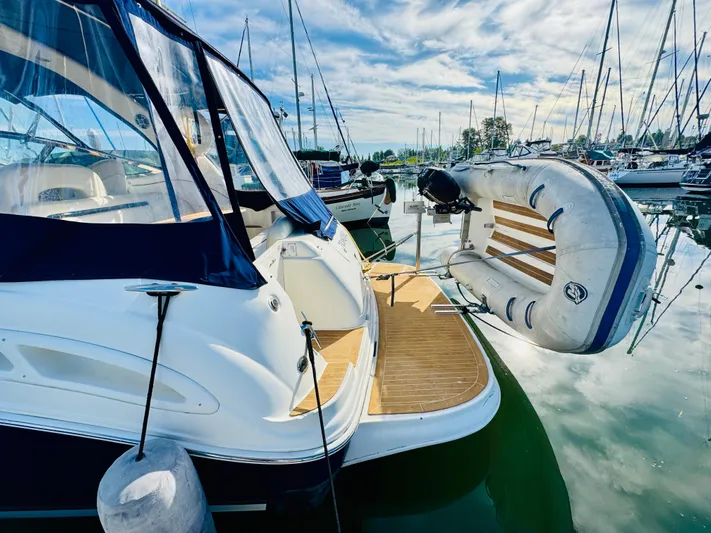 Tranquilo Yacht Photos Pics 2004 Sea Ray 360 Sundancer yacht docked with inflatable boat, under a clear sky.