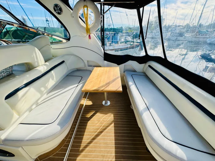 Tranquilo Yacht Photos Pics 2004 Sea Ray 360 Sundancer interior with white seating and wooden table, docked at marina.