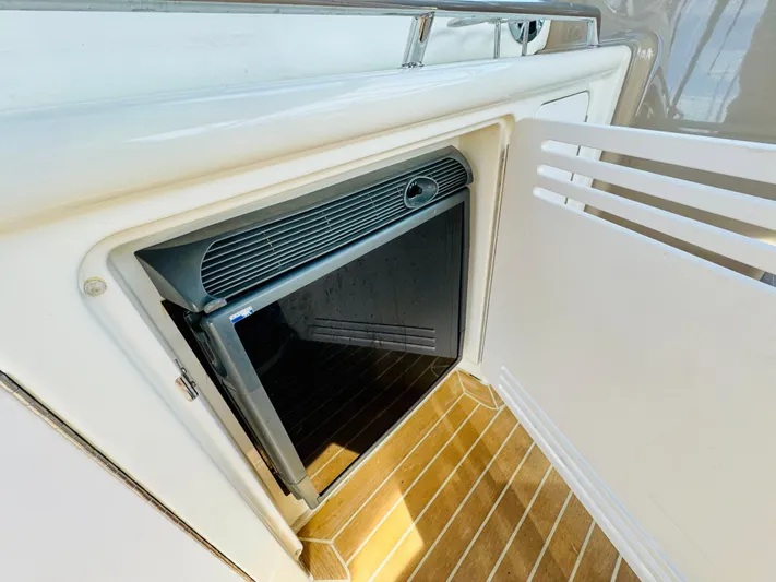 Tranquilo Yacht Photos Pics 2004 Sea Ray 360 Sundancer mini fridge with open door on wooden deck.