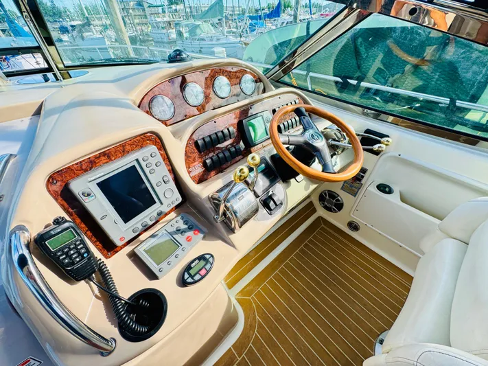 Tranquilo Yacht Photos Pics 2004 Sea Ray 360 Sundancer helm with wood accents and modern navigation equipment.