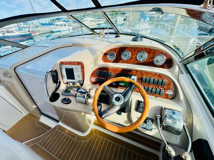 Tranquilo Yacht Photos Pics 2004 Sea Ray 360 Sundancer helm with wood accents and modern controls.