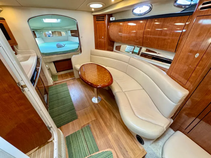 Tranquilo Yacht Photos Pics 2004 Sea Ray 360 Sundancer interior with curved seating, wooden table, and modern design.