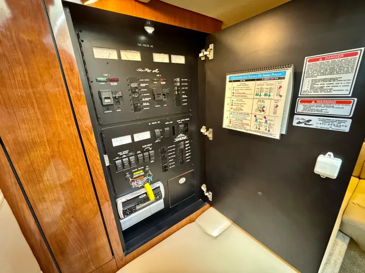 Tranquilo Yacht Photos Pics Electrical panel inside a 2004 Sea Ray 360 Sundancer yacht, featuring switches and safety instructions.