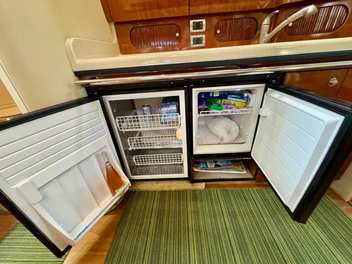 Tranquilo Yacht Photos Pics 2004 Sea Ray 360 Sundancer galley with open fridge and freezer, showcasing interior storage.