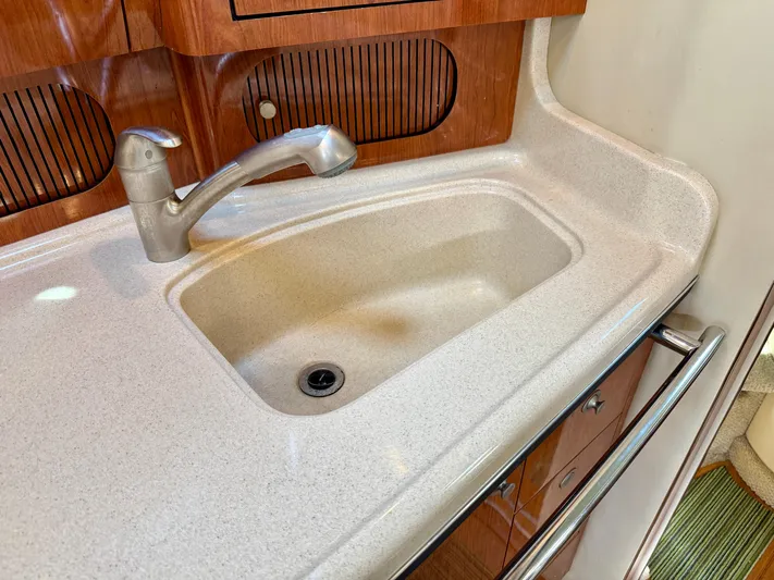 Tranquilo Yacht Photos Pics 2004 Sea Ray 360 Sundancer kitchen sink with modern faucet and wooden cabinetry.