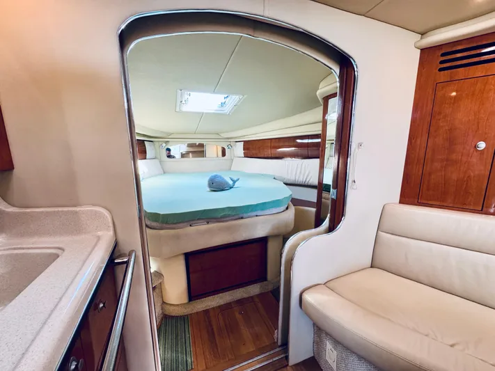 Tranquilo Yacht Photos Pics 2004 Sea Ray 360 Sundancer cabin interior with bed, seating, and wooden accents.