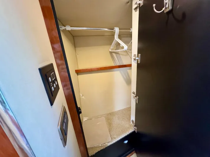 Tranquilo Yacht Photos Pics Closet interior on 2004 Sea Ray 360 Sundancer yacht with hangers and control panel.