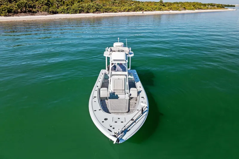  Yacht Photos Pics 2023 Barker Boatworks 26 Open on calm water near a sandy shoreline.