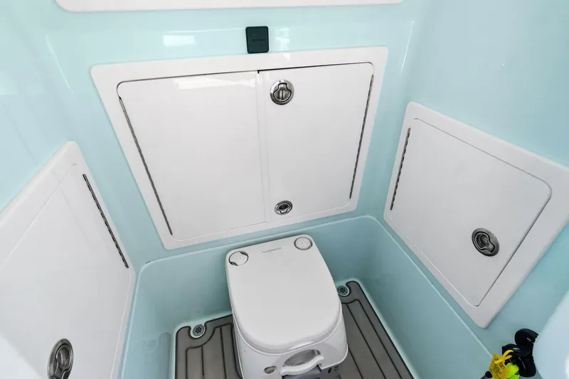  Yacht Photos Pics 2023 Barker Boatworks 26 Open interior with compact marine toilet and storage compartments.