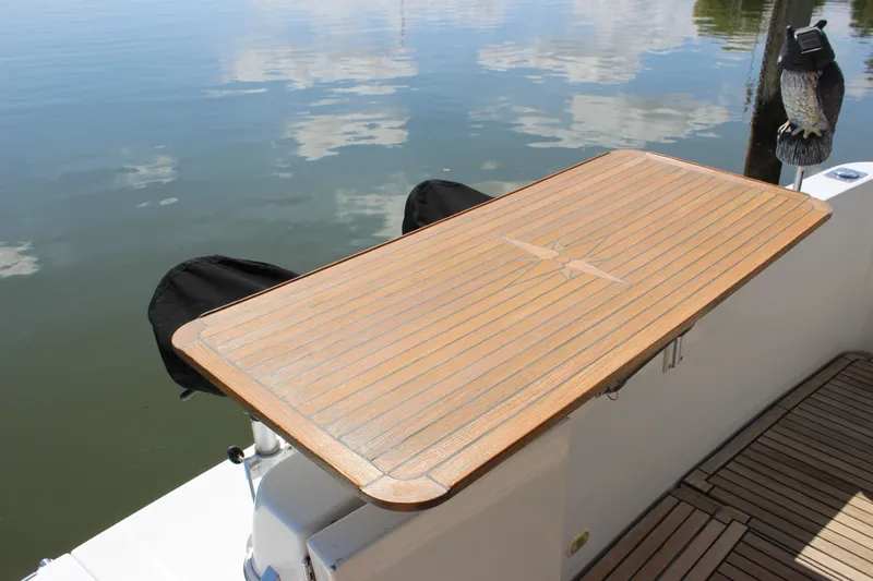  Yacht Photos Pics Teak table on 2003 Carver 36 Super Sport yacht, docked by calm water.