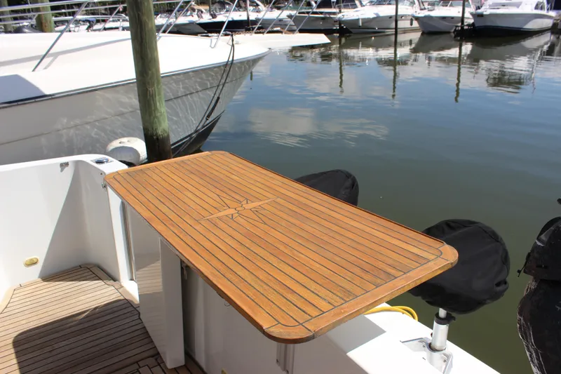  Yacht Photos Pics 2003 Carver 36 Super Sport yacht with wooden deck table in marina setting.