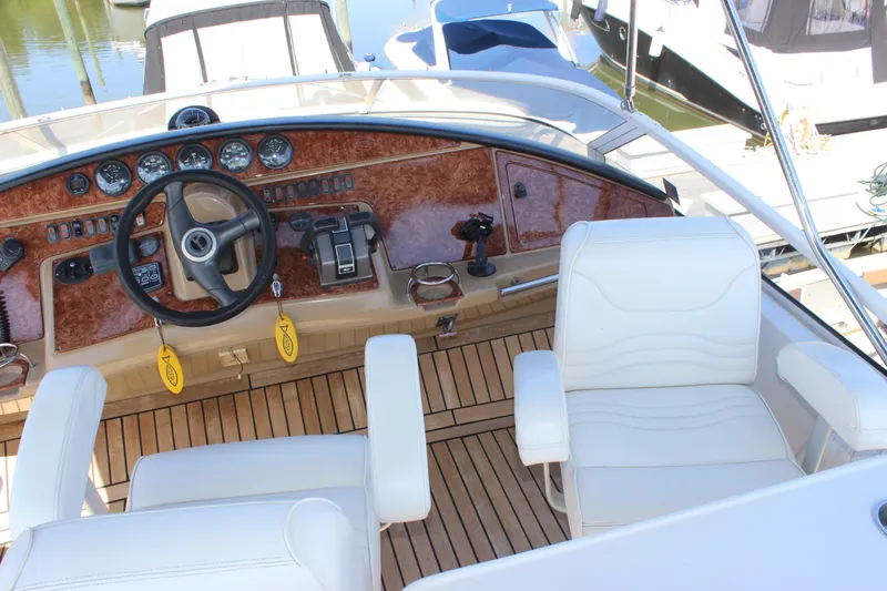  Yacht Photos Pics 2003 Carver 36 Super Sport yacht helm with white seating and wood dashboard.
