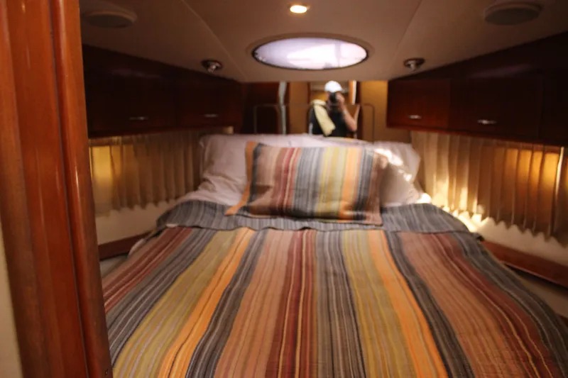  Yacht Photos Pics Interior of 2003 Carver 36 Super Sport with striped bedding and wooden cabinets.