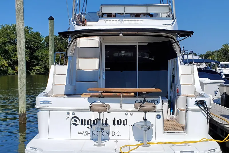  Yacht Photos Pics 2003 Carver 36 Super Sport yacht docked, featuring outdoor seating and "Dugout Too" name.