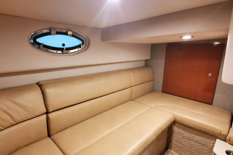  Yacht Photos Pics 2010 Formula 31 Performance Cruiser interior with beige leather seating and porthole window.