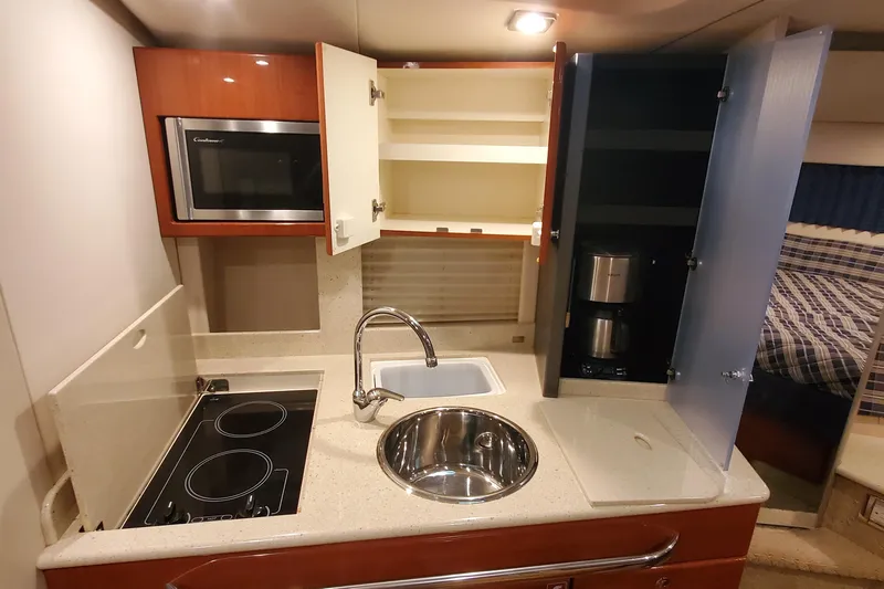  Yacht Photos Pics 2010 Formula 31 Performance Cruiser kitchen with stove, sink, microwave, and open cabinets.