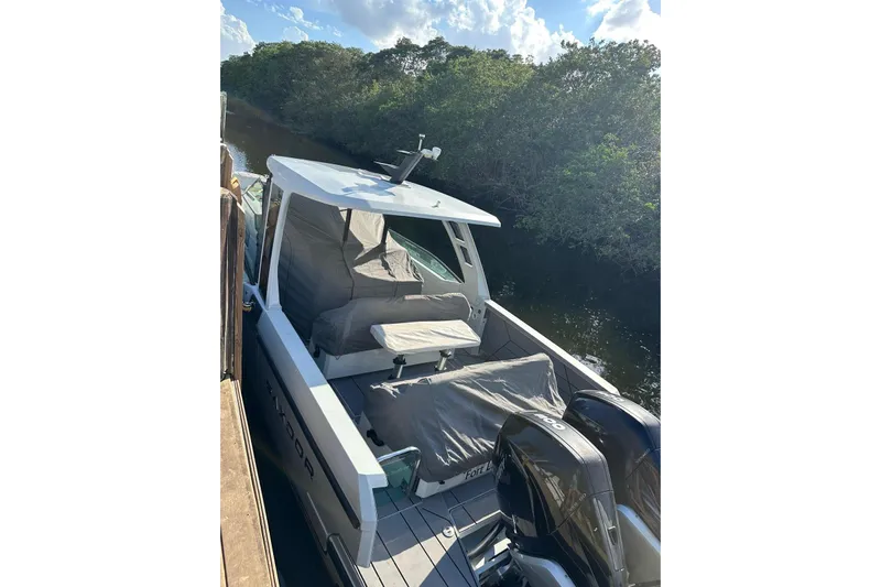 La Flare Yacht Photos Pics 2023 Saxdor 320 GTO boat docked by a lush riverside under a clear sky.