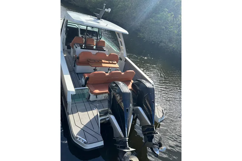 La Flare Yacht Photos Pics 2023 Saxdor 320 GTO boat with dual engines and orange seating on a calm waterway.