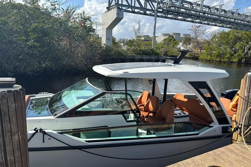 La Flare Yacht Photos Pics 2023 Saxdor 320 GTO boat docked by a scenic waterway with lush greenery.