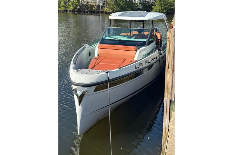 La Flare Yacht Photos Pics 2023 Saxdor 320 GTO boat docked, featuring sleek design and orange seating.