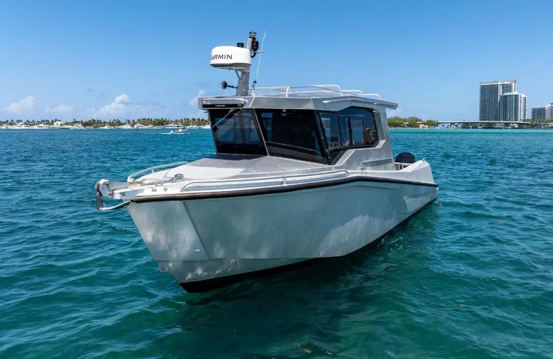  Yacht Photos Pics 2026 Novielli Alaskan 296 boat on clear blue water near city skyline.