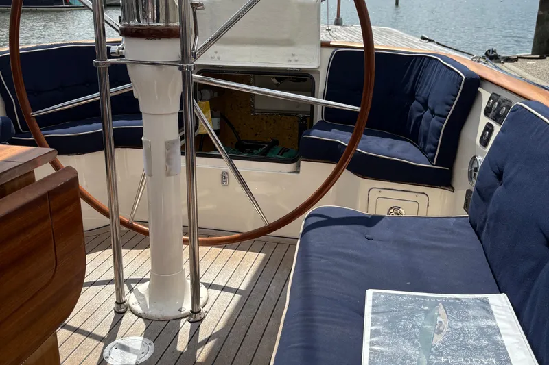 Arethusa Yacht Photos Pics Cockpit of 2017 Leonardo Eagle 44 sailboat with wooden wheel and navy cushions.