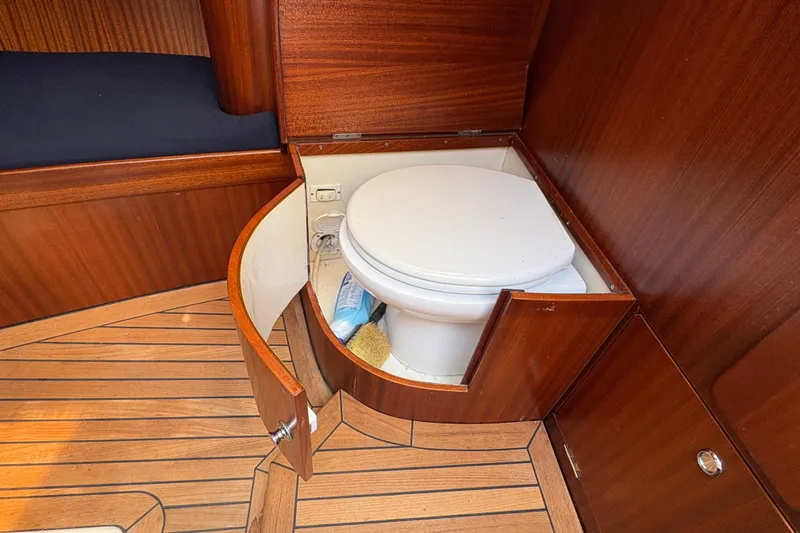 Arethusa Yacht Photos Pics Wooden yacht bathroom with toilet, featuring elegant cabinetry in a 2017 Leonardo Eagle 44.
