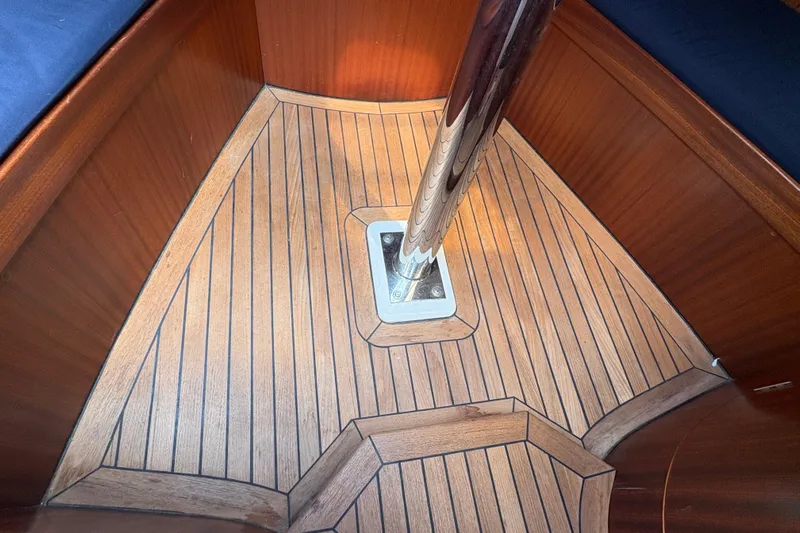 Arethusa Yacht Photos Pics Teak interior flooring of 2017 Leonardo Eagle 44 sailboat, featuring polished metal support.