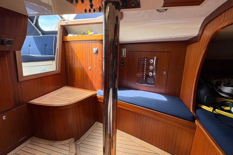Arethusa Yacht Photos Pics Interior of 2017 Leonardo Eagle 44 yacht with wooden paneling and blue seating.