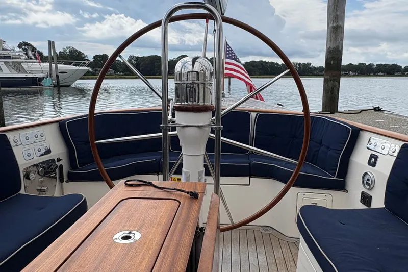 Arethusa Yacht Photos Pics Cockpit of 2017 Leonardo Eagle 44 sailboat with wooden wheel and blue seating.