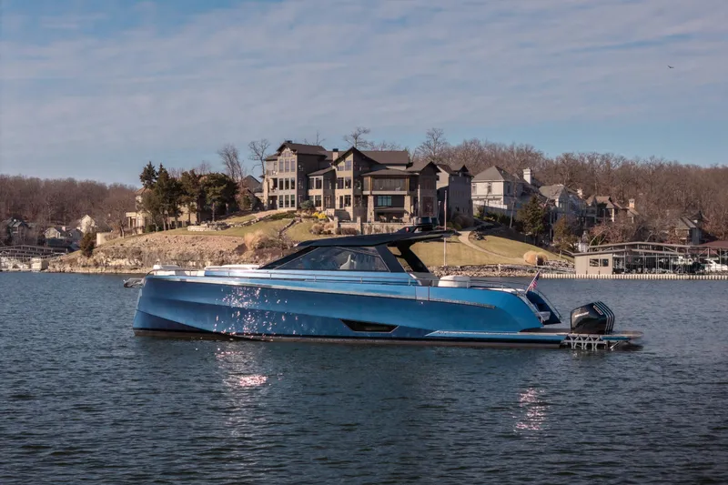  Yacht Photos Pics Luxurious 2025 Dutch American DA 53 yacht on a serene lake with elegant homes in the background.
