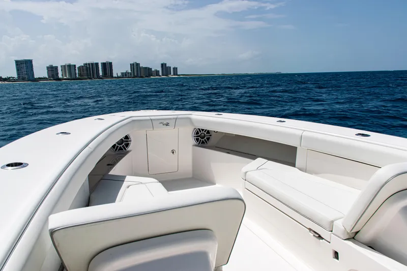  Yacht Photos Pics 2025 SeaVee 400Z boat with white seating, ocean view, and city skyline in the background.