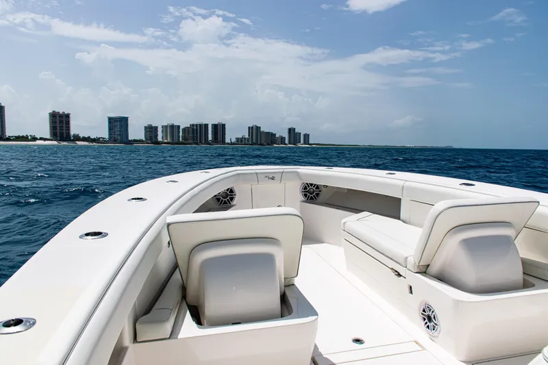  Yacht Photos Pics 2025 SeaVee 400Z boat on ocean, city skyline in background, clear sky.