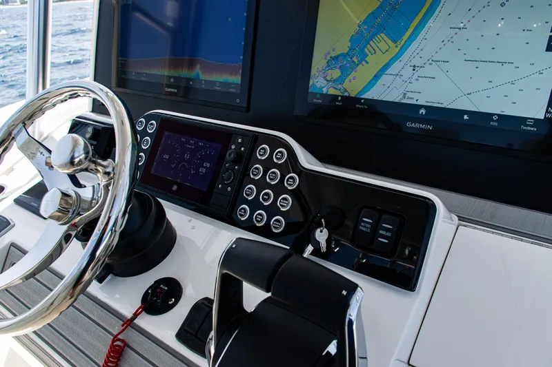  Yacht Photos Pics Control panel of 2025 SeaVee 400Z boat with navigation screens and steering wheel.