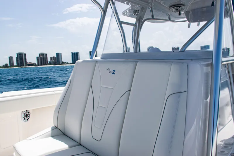  Yacht Photos Pics 2025 SeaVee 400Z boat interior with white seating, ocean and city skyline in background.