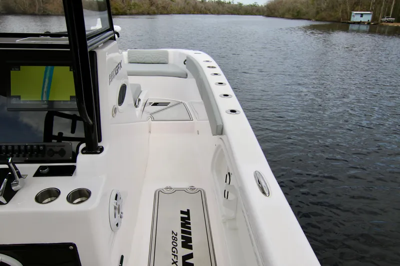  Yacht Photos Pics 2024 Twin Vee 280 GFX CC boat interior with console and seating on calm water.