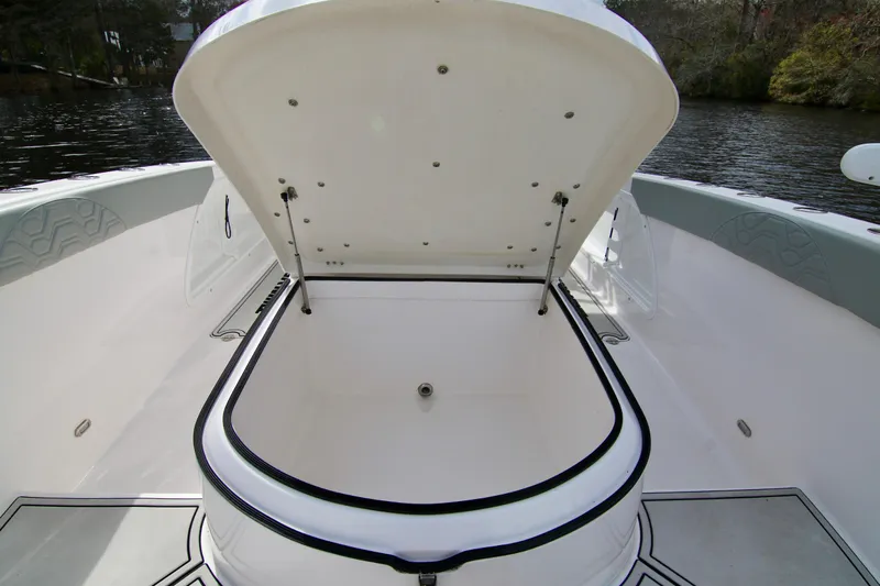  Yacht Photos Pics 2024 Twin Vee 280 GFX CC boat with open storage compartment, on calm water.