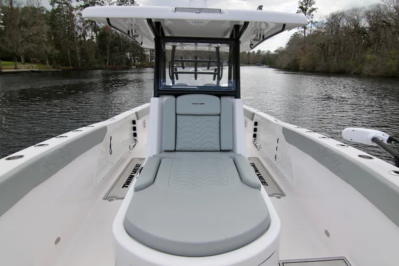  Yacht Photos Pics 2024 Twin Vee 280 GFX CC boat on a serene river, showcasing sleek design and comfort.