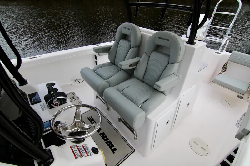  Yacht Photos Pics 2024 Twin Vee 280 GFX CC boat interior with dual captain's chairs and steering wheel.