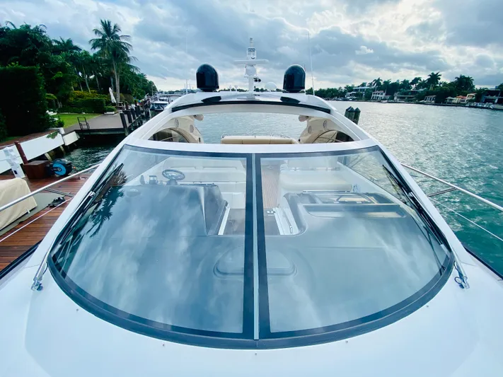 Essence Yacht Photos Pics 2010 Sunseeker Predator 60 yacht docked by a scenic waterfront.